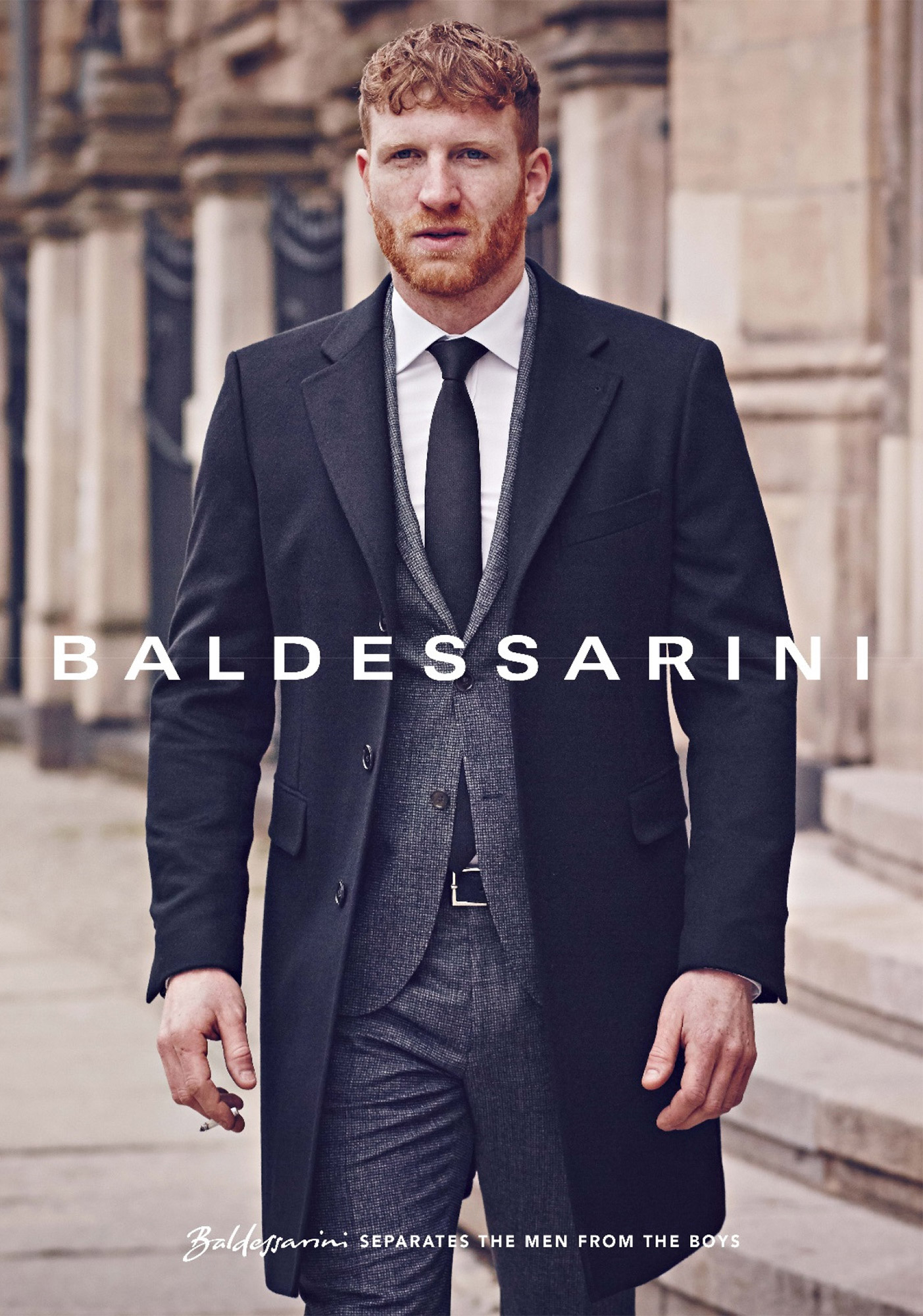 Baldessarini campaign: man in a dark coat over a grey three-piece suit, walking past stone columns
