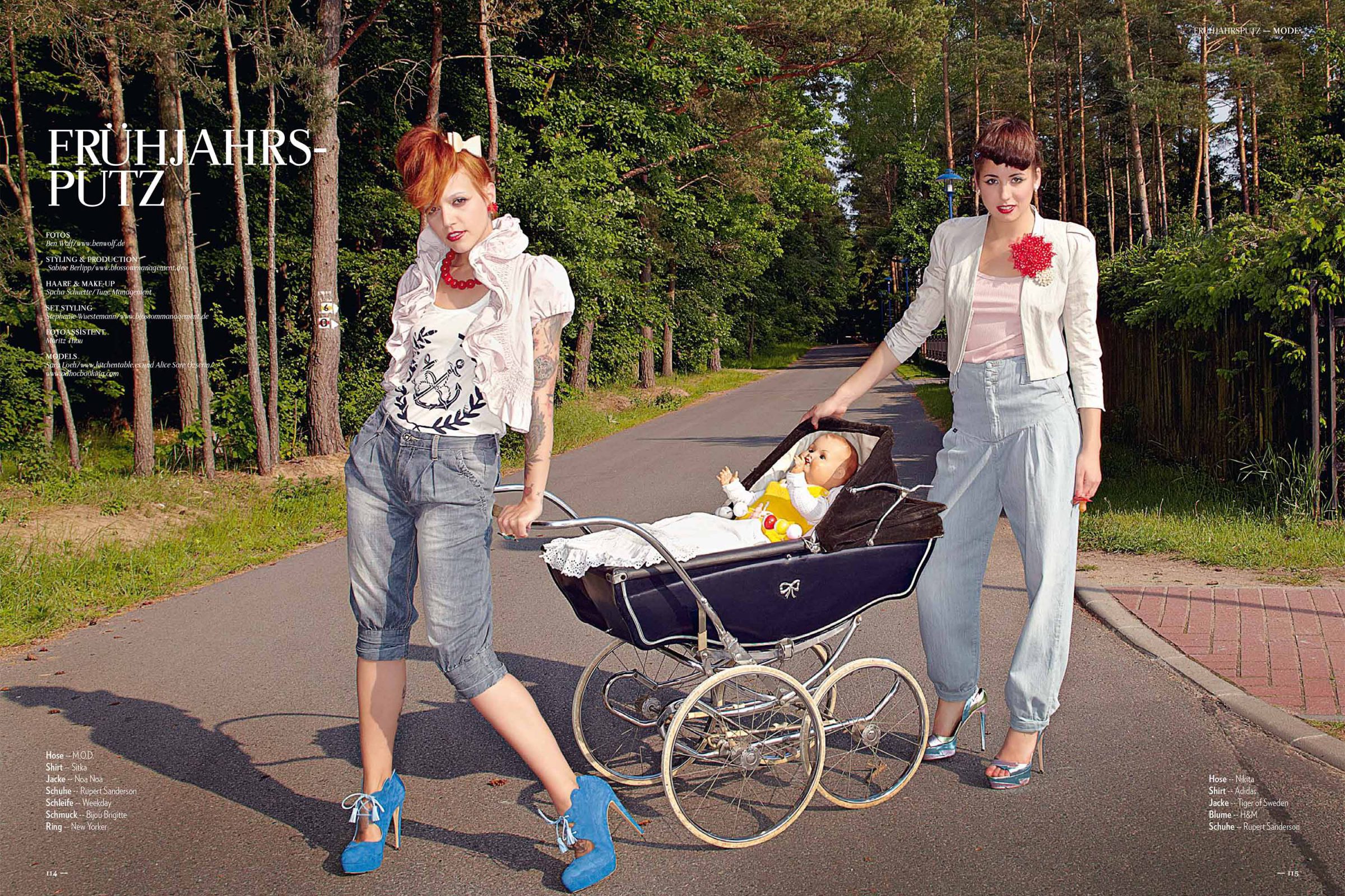 Opening spread of the "Frühjahrsputz" story: two models with a vintage pram on a forest road